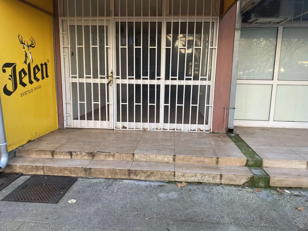 Izlog poslovnog prostora u Trebinju sa metalnom zaštitom i stepenicama ispred ulaza